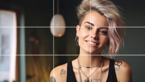 Smiling woman with pastel pink hair and tattoos framed by a rule of thirds grid overlay